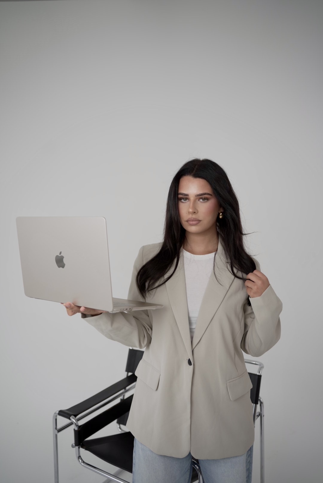 A Tagged Agency team member holding an open laptop in a minimalist Dubai studio